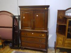 A mahogany linen press in 19th century style, the upper section with a pair of panelled doors