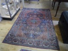 A Kashmir rug, the central lozenge within a geometric and foliate pattern on a blue ground. 210cm by