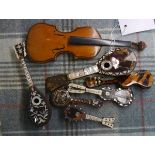 A group of six miniature tortoiseshell string instruments including lutes and guitars, some inset