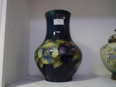 A William Moorcroft vase in the Pansies pattern, of baluster form, against a shaded blue ground,