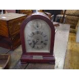 A 1920's mahogany cased mantel clock, of arched form, the silvered dial with Roman numerals and