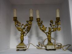 A pair of gilt metal figural candelabra in the Rococo taste, each modelled with a musical satyr