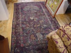 A "Tree of Life" rug, decorated with a peacock, exotic birds and animals, within a foliate border.