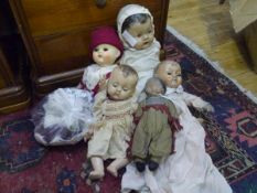 A group of five vintage dolls with clothing