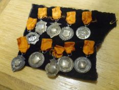 A collection of ten early 20th century silver fobs and medals, one with enamel crest, various