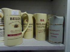 A group of seven branded pub whisky water jugs including Whyte & Mackay, Bells etc