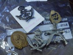 A bag of five military and other badges including Gurkhas and Womens Land Army