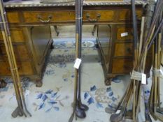 A group of five vintage golf clubs, some hickory shafted