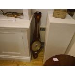 An inlaid mahogany barometer in the George III taste, decorated with paterae and with urn finial.