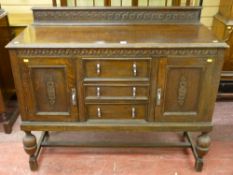 A circa 1930's oak railback sideboard of three central drawers and two flanking cupboards on bulbous