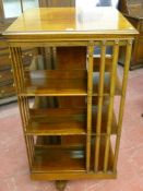 A large Edwardian mahogany revolving bookcase with slatted ends on a quatrefoil base with brass