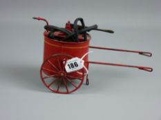 A vintage tinplate model of a firefighter's waterpump barrow with lever action pump and hose,