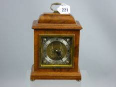 An Elliott walnut encased mantel clock, square faced with circular silvered dial set with Roman