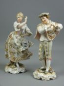 A pair of Rudolstadt Volkstedt porcelain figures in floral hand painted period costume of a flute