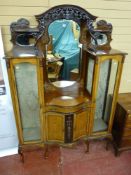An Edwardian mahogany serpentine front display cabinet with triple mirrored pierced frieze top,