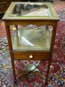 A Victorian mahogany display case with bevelled glass lidded top and shaped frieze, central single