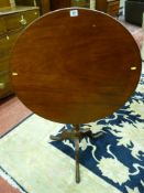 An antique mahogany circular tilt top tripod table, 74 cms high, 73 cms diameter top