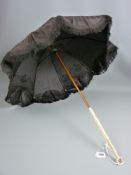 A 19th Century lady's parasol with carved ivory handle and top, the embossed dark coloured canopy