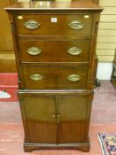 A reproduction mahogany chest on cabinet with quarter cut turned pillars, three top drawers with