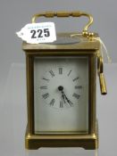 A circa 1900 brass carriage clock with bevelled edge glass panels and oval escapement viewing