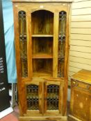 A modern Mexican hardwood and wrought iron corner cabinet with two door base on a raised plinth, 183