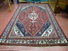 A red ground Persian village rug, approximately 297 x 190 cms