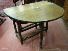 A 19th Century oak gate leg table on turned legs having moulded edge stretchers on turned bun