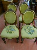 A set of four late 19th Century walnut salon chairs having spoon shaped backs with carved top