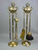 A four piece brass fireside companion set on twin ring handled stands