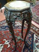 A Chinese carved hardwood stand with inset marble top (marble cracked), pierced floral frieze and