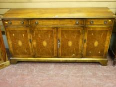A reproduction yew wood top sideboard with three frieze drawers and four cupboard doors with quarter