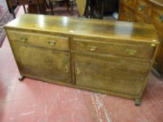 A two drawer, two door sideboard base on platform feet, narrow depth with chamfered edge drawers and