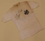 A RARE SANTOS FC CLUB SHIRT SIGNED BY 'EDSON PELE' (PELE) SIGNED DIAGONALLY ACROSS THE CHEST.