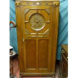 A good 20th Century carved oak hall robe, the single door with inset carved roundel, further