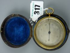 A 19th Century pocket barometer in a gilt brass case and revolving bezel and silvered dial, the rear