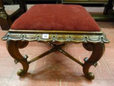 A carved mahogany square footstool with burgundy draylon top on shaped supports with turned cross