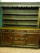 An 18th Century North Wales oak dresser, the three shelf wide boarded rack with shaped front