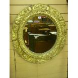 A 19th Century circular pine mirror with gilt decorated gesso floral relief, 67 cms diameter (gilt