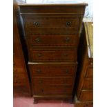 A reproduction crossbanded mahogany one piece chest on chest having six drawers with brass ring