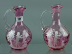 Two cranberry glass claret jugs, dimple patterned glass with ribbed handle and Mary Gregory