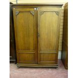 A 20th Century oak two door compactum style wardrobe with fitted interior, trademarked 'The