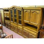 A 20th Century Dutch oak three part display unit of central arched top, triple glazed door display