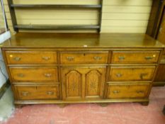 A George III oak dresser base, the twin plank moulded top over an arrangement of seven drawers