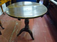An antique oak circular top tripod table on a turned column support (feet reduced), 72 cms high,