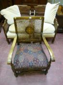 An oak upholstered armchair with carved front rail and Bergere back and a pair of armchairs with