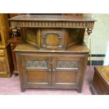 A good quality reproduction oak court cupboard having a deep carved frieze, carved arch inset