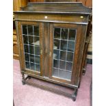 An oak two door railback bookcase with leaded glass doors on barley twist supports, 145 cms