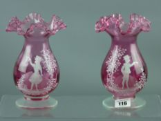 A pair of cranberry glass vases with ruffled necks, dimpled bulbous body on a squat foot with Mary
