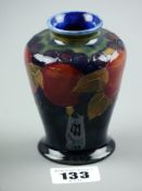 A small Moorcroft Pomegranate baluster shaped vase with impressed factory marks to the base (
