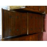 A reproduction crossbanded mahogany one piece chest on chest having six drawers with brass ring